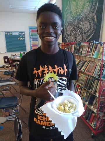 student holding his pasta bowl 