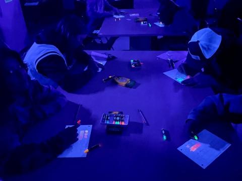 students shading forms with black light 