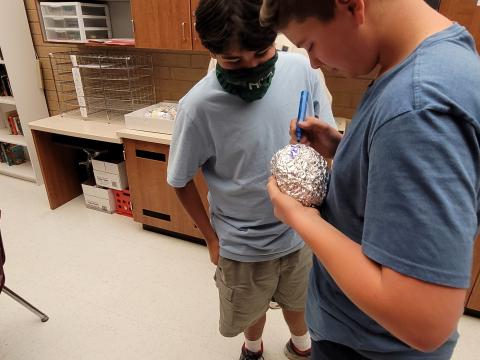 students engineering devices to protect egg-stronauts