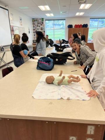 students learning to take care of infant simulators 