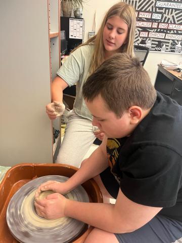 students using pottery wheels in ceramics