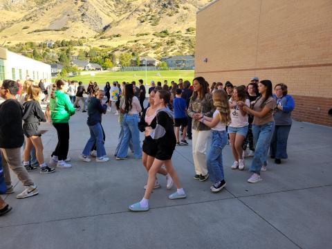 8th grade students participating in a round dance.